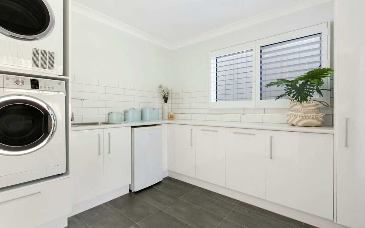 Bright residential laundry room with a stacked washer and dryer.